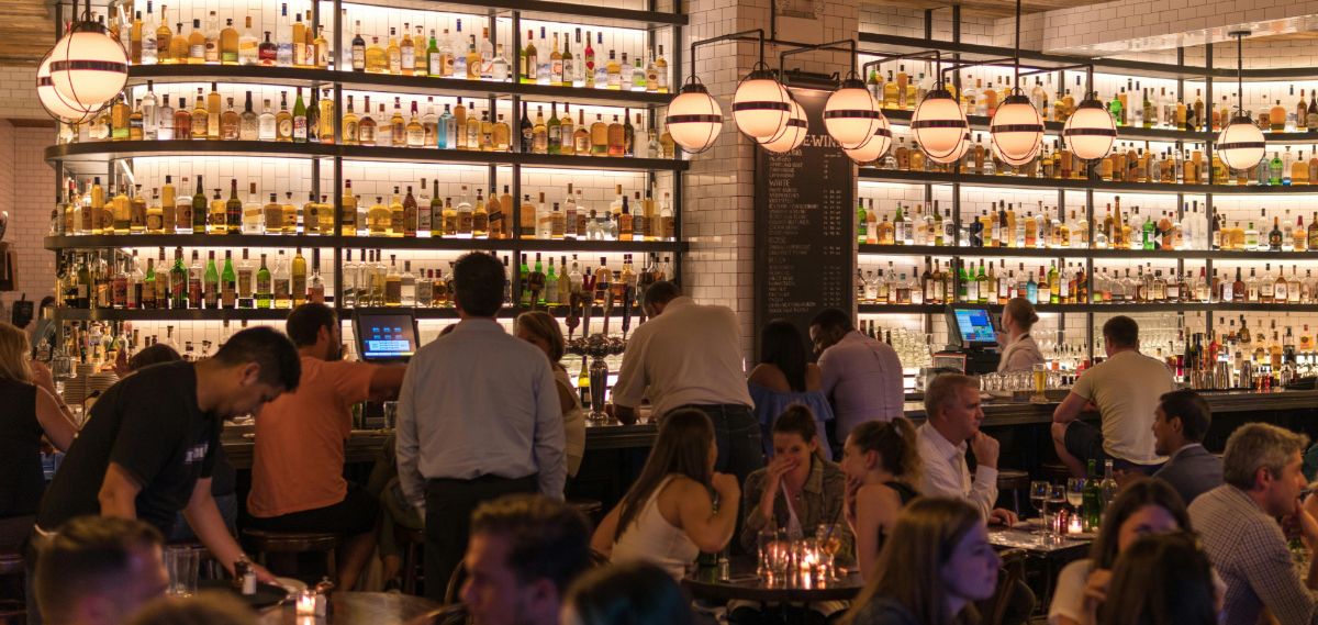 Ein stilvoll beleuchteter Restaurantbereich mit Bar und Sitzplätzen.