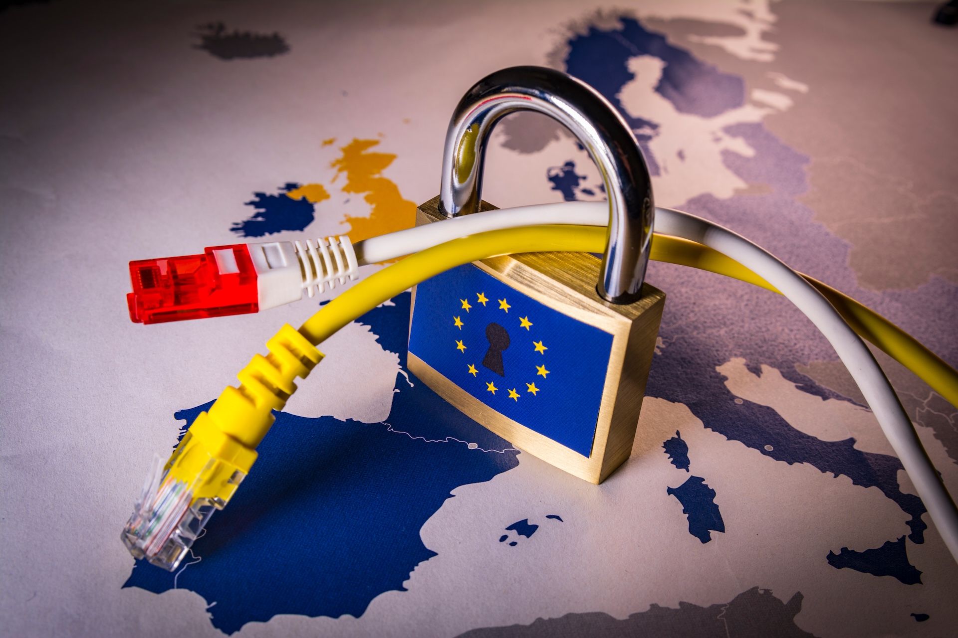 Ein Schloss mit einer EU-Flagge darauf, durch das zwei LAN-Kabel gesteckt sind.