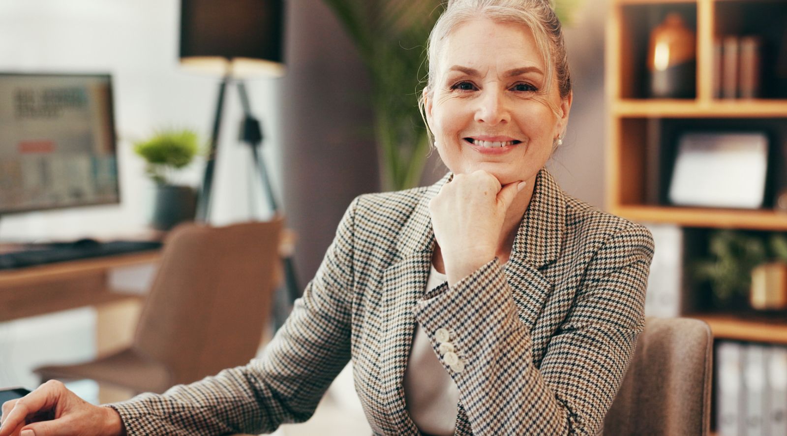 Ein Rechtsanwalt in einer modernen Kanzlei mit Akten und Laptop auf dem Schreibtisch.