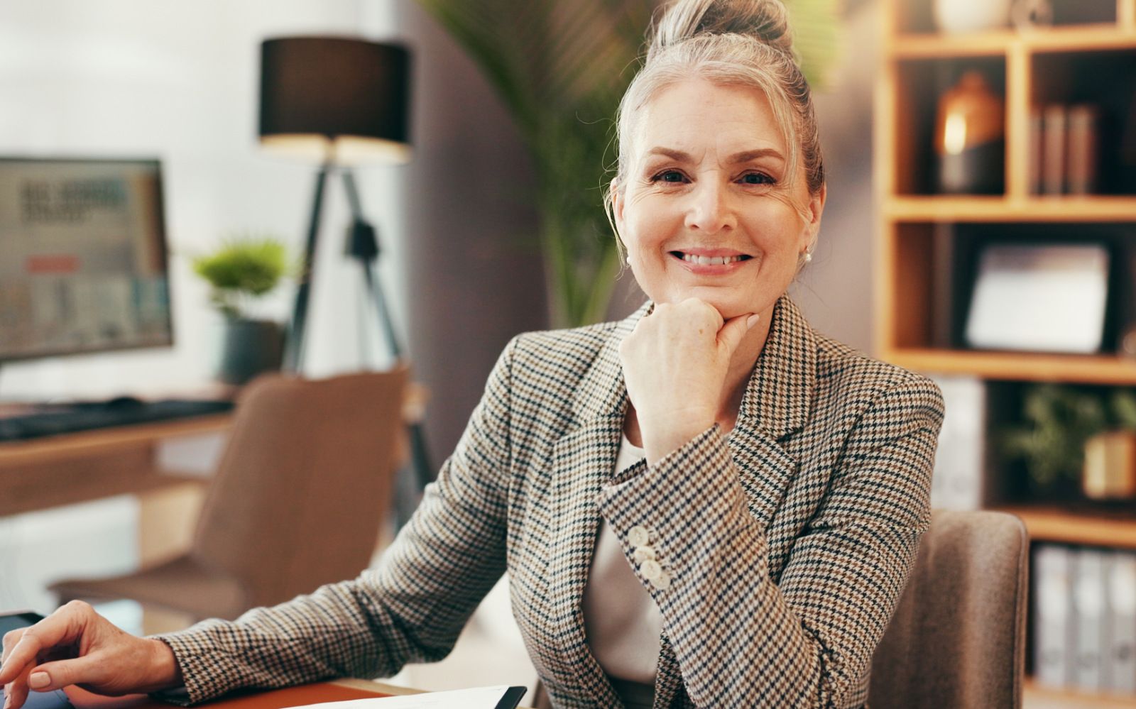 Ein Rechtsanwalt in einer modernen Kanzlei mit Akten und Laptop auf dem Schreibtisch.