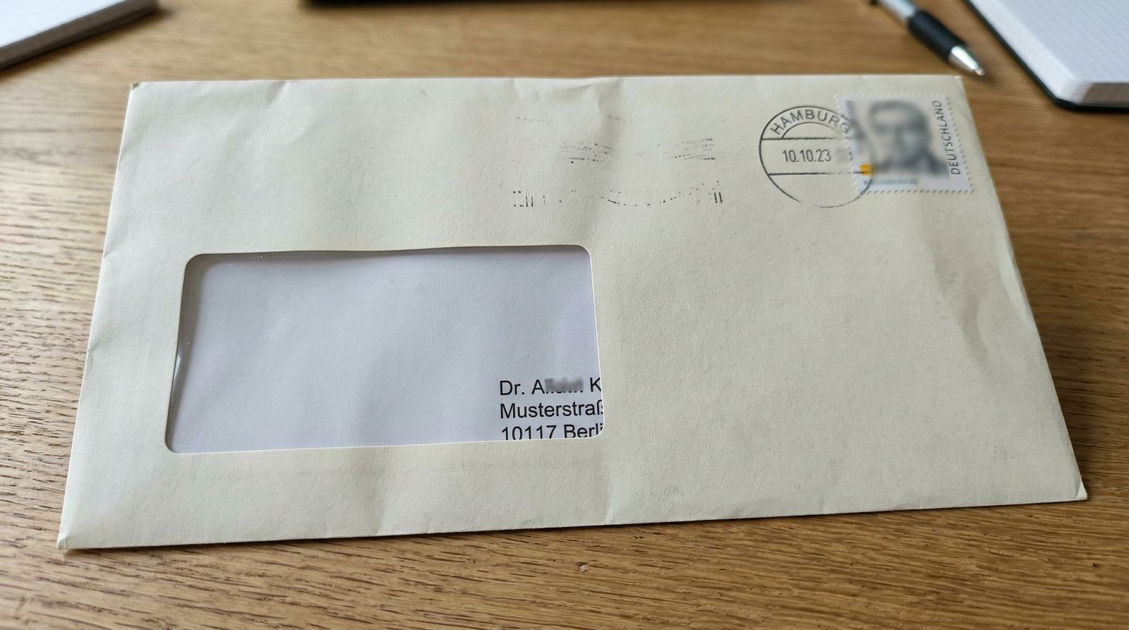 Ein Briefumschlag im Sichtfenster, jedoch ist die Empfängeradresse verrutscht und kann nicht vollständig gelesen werden