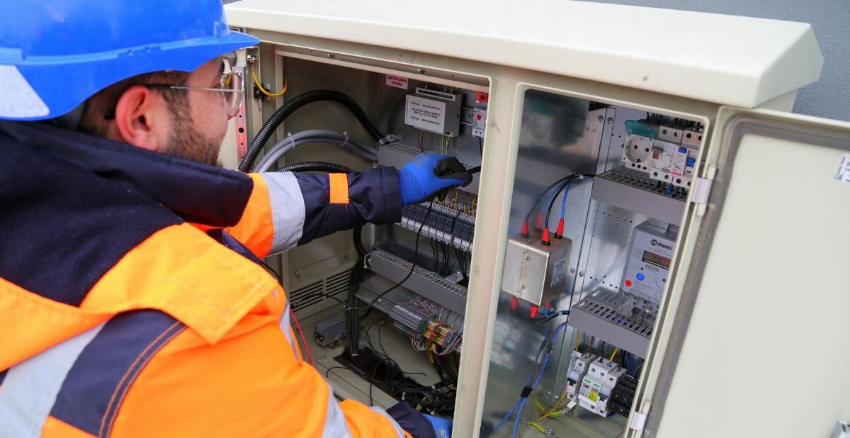 Ein Elektriker bei der Arbeit an einer Schaltanlage als Symbolbild für professionelles Webdesign für Elektriker