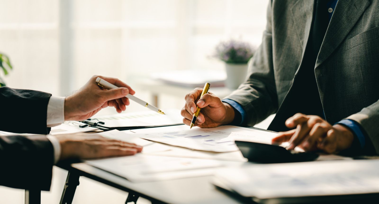 Eine Steuerberaterin in einer modernen Kanzlei mit Laptop und Unterlagen auf dem Schreibtisch.